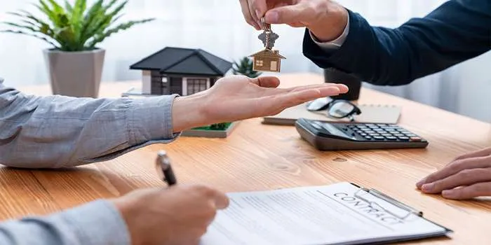 اصطلاحات رایج در زمینه املاک که باید با آنها آشنا شوید _ تصویری از دستهای دو فرد که در حال قرارد بستن در زمینه املاک هستند.